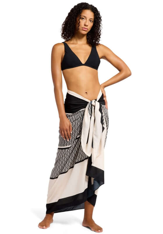 Black Spring Geo Long Sarong by Jets, model wearing a black and ivory geometric sarong over swimwear.