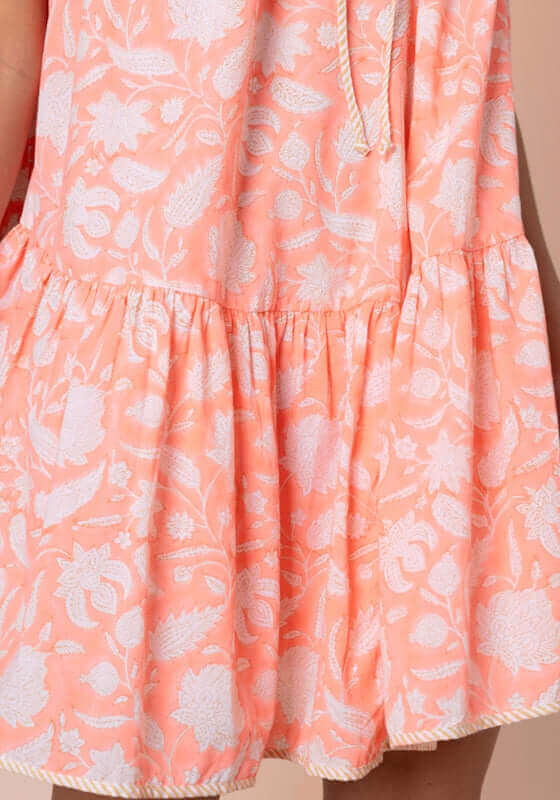 Pomegranate Strappy Mini Dress Neon Red by Juliet Dunn, close-up of floral fabric detail and ruffled hem design.