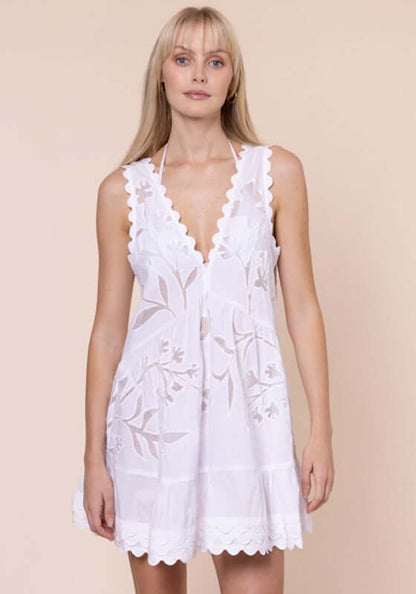 Floral Cutwork V Neck Mini Dress White by Juliet Dunn; model wearing a white mini dress with floral cutwork and a plunging V neckline.