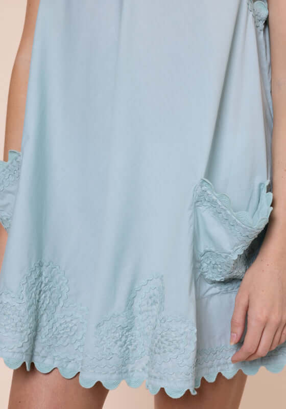 Ric Rac Low Back Dress Pistachio by Juliet Dunn, showcasing the soft fabric and playful patch pockets design.