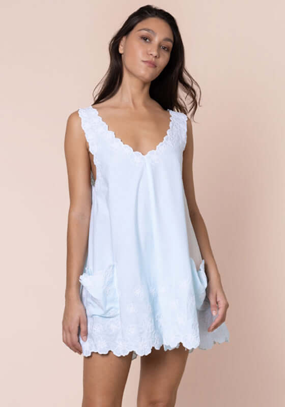 Poplin Floral Low Back Dress Ice Blue by Juliet Dunn, a model showcases a breezy, chic dress with pockets.
