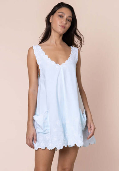 Poplin Floral Low Back Dress Ice Blue by Juliet Dunn, a model showcases a breezy, chic dress with pockets.