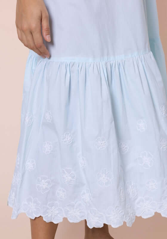 Poplin Floral Midi Dress Ice Blue by Juliet Dunn, featuring delicate floral embroidery on the hem of a light blue dress.
