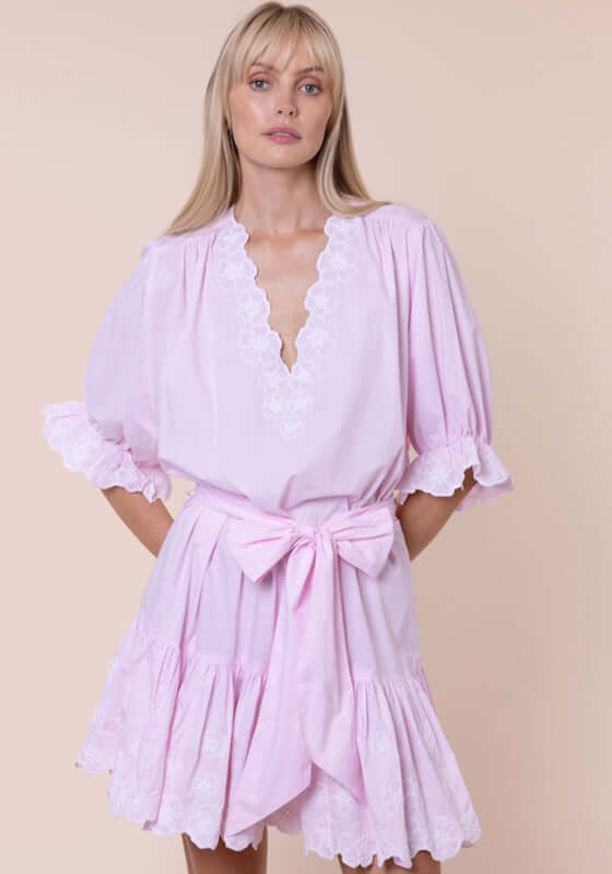 Poplin Floral Tie Waist Dress Petal Pink by Juliet Dunn, showcasing a model wearing a light pink dress with tie waist and ruffles.