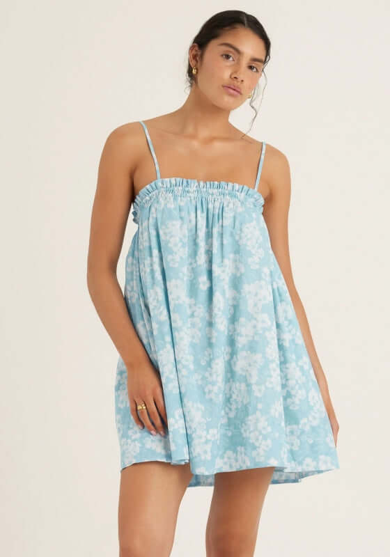 Ruched Mini Dress Paper Daisy by Peony, featuring a breezy blue and white floral print with delicate straps.