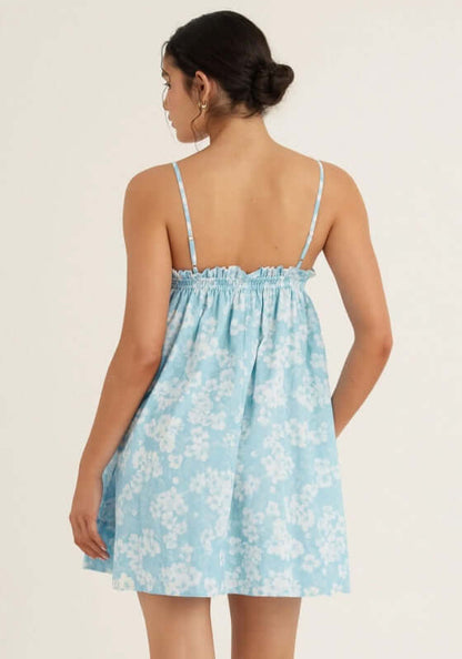 Ruched Mini Dress Paper Daisy by Peony, showing a back view of a blue and white floral mini dress with thin straps.