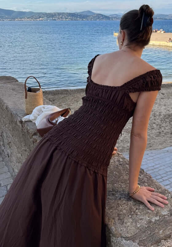 Sonnet Midi Dress Pecan by Peony, showcasing a smocked bodice and sweetheart neckline by the seaside.