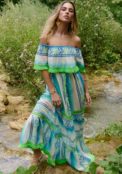 Frida Long Dress Aqua by Piti Cuiti, featuring an off-shoulder design and flowing silhouette in vibrant aqua and green tones.