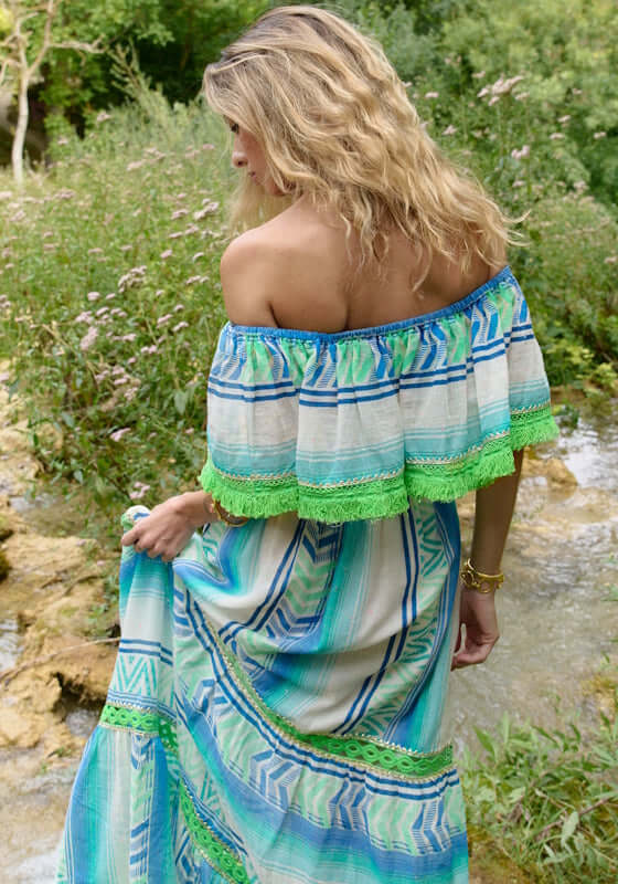 Frida Long Dress Aqua by Piti Cuiti, off-shoulder maxi dress with flowing silhouette and fringe trim in aqua tones.