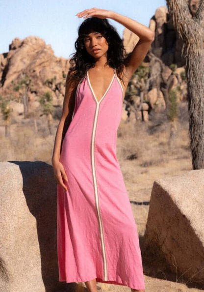 Pima Inca Dress Bubblegum by Pitusa model wearing a pink dress with a deep neckline in a desert setting.