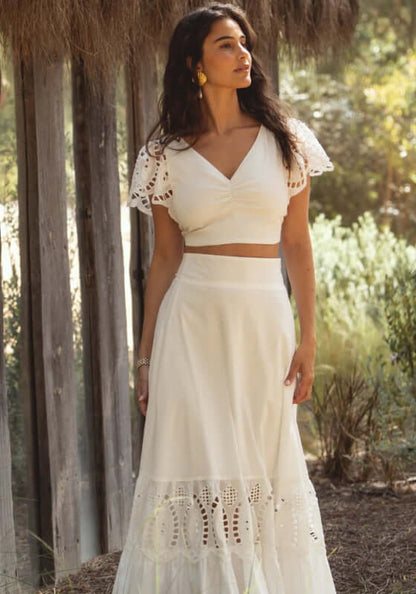 Mallorca Top White by Sole Lisboa, showcasing a woman in a cropped white top with frilly sleeves and a flowy skirt.