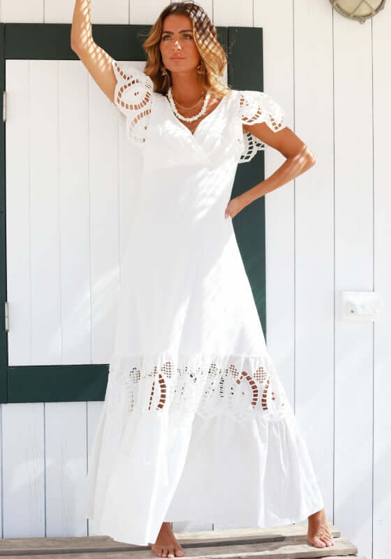 Copacabana Dress White by Sole Lisboa, featuring a V-neckline, peplum skirt, eyelet cutouts, and frill sleeves.
