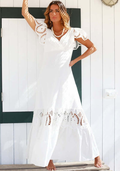 Copacabana Dress White by Sole Lisboa, featuring a V-neckline, peplum skirt, eyelet cutouts, and frill sleeves.