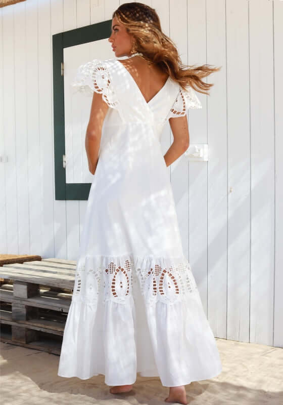 Copacabana Dress White by Sole Lisboa, featuring a V-neckline, peplum skirt, and eyelet cutout details on a model.