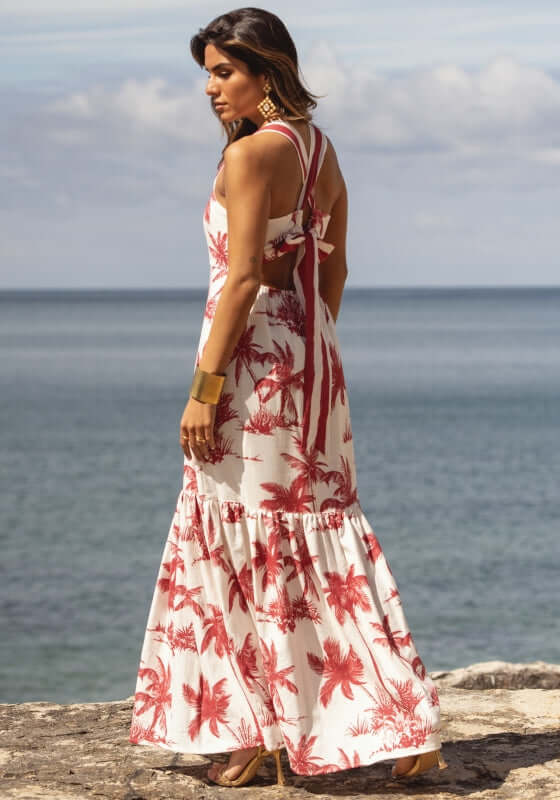 Emilie Dress Palm Red by Sole Lisboa, showcasing a flowy maxi design with a palm tree pattern, perfect for beach settings.
