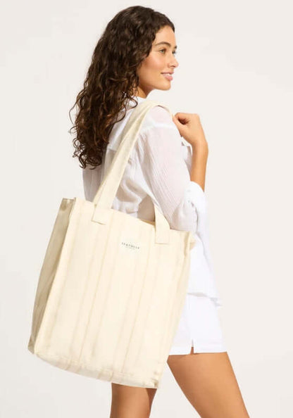 Aurora Tote Beach Bag Sand by Seafolly, a model holding a stylish, practical beach tote bag in a light beige color.