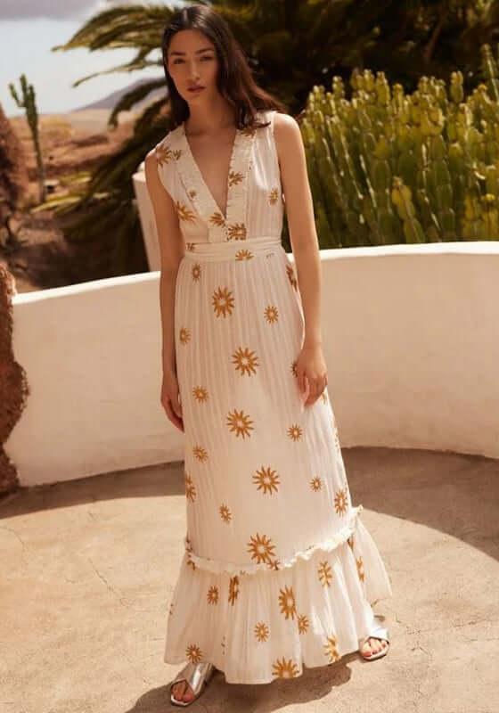 Begonia Dress New Dubai by Sundress, sleeveless white beach dress with gold suns, ruched V-neckline, flowing long skirt.