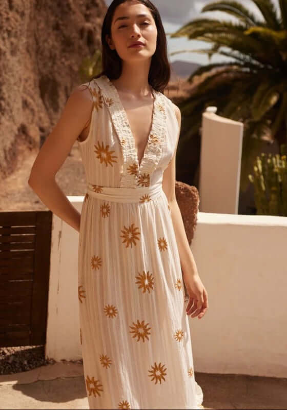 Begonia Dress New Dubai by Sundress, a sleeveless beach dress with a ruched V-neckline and gold sun patterns.