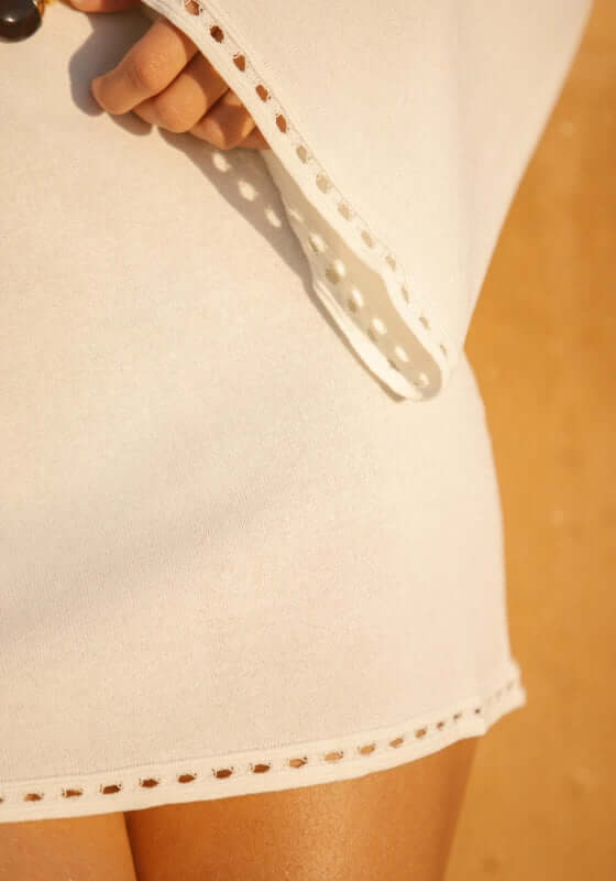 Mahe Dress Ivory by Away That Day close-up of the textured trim and flare sleeve detail.