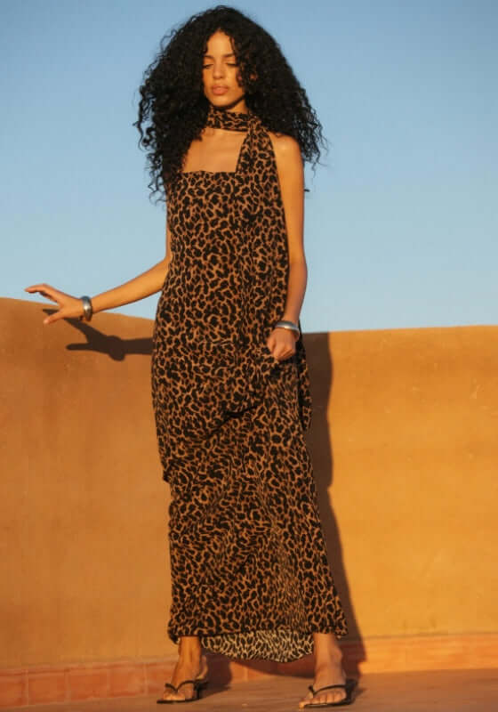 St Tropez Dress Leopard by Away That Day, featuring a woman in a leopard print maxi dress with spaghetti straps and a matching scarf.