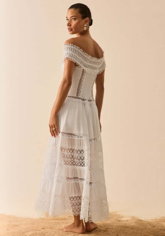 Amaira Dress White by Sole Lisboa, elegant long white dress showcasing off-shoulder neckline and tiered skirt.