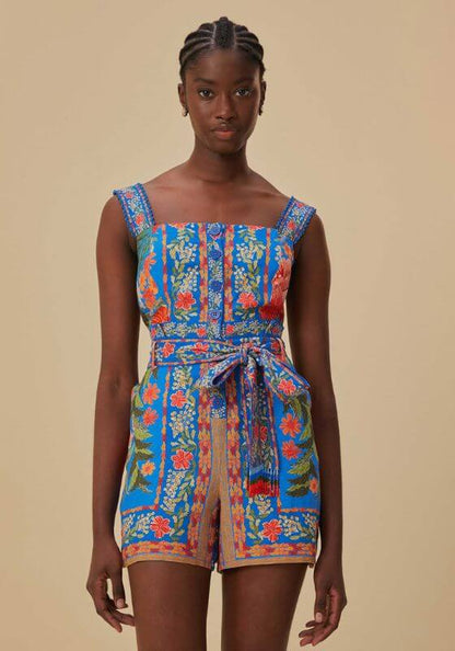Stiched Garden Blue Romper by Farm Rio, model wearing a vibrant floral playsuit with a square neckline and tie belt.
