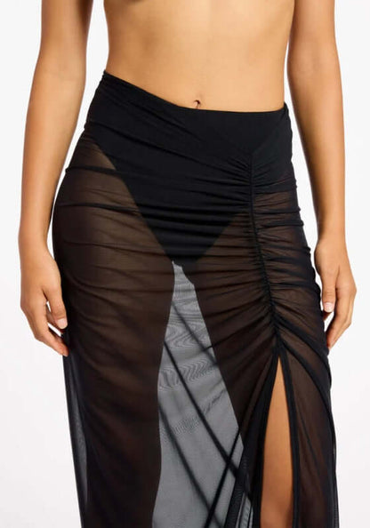 Jetset Lure Mesh Skirt by Jets Swimwear, showcasing sheer black fabric with side ruching and a high slit.