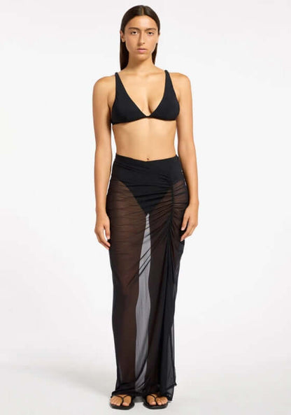 Jetset Lure Mesh Skirt by Jets Swimwear, model wearing a black sheer maxi skirt with side ruching.