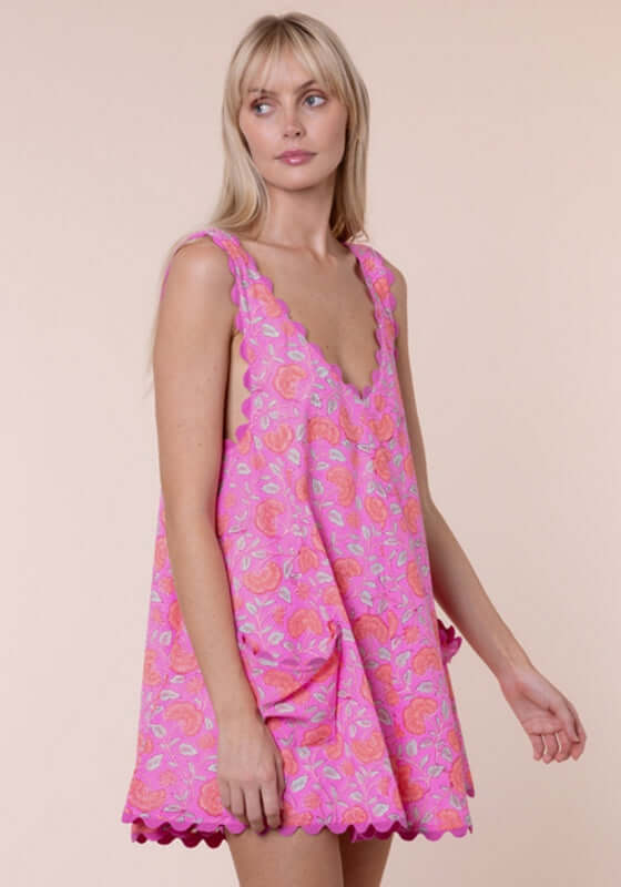 Floral Low Back Dress Fuchsia by Juliet Dunn, showcasing a model in a pink floral mini dress with a scalloped hem.