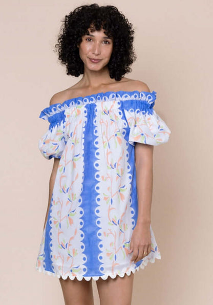 Birds Of Paradise Off Shoulder Dress by Juliet Dunn, featuring a model in a vibrant blue floral off-shoulder dress.