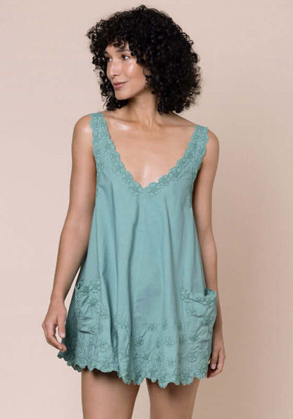 Poplin Floral Low Back Dress Cactus by Juliet Dunn, showing a model in a cactus green dress with pockets.