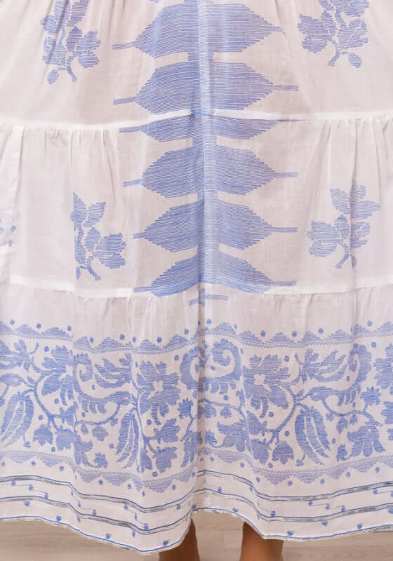 Dhaka V Neck Kaftan Blue by Juliet Dunn, showcasing detailed blue embroidery on a lightweight white fabric.