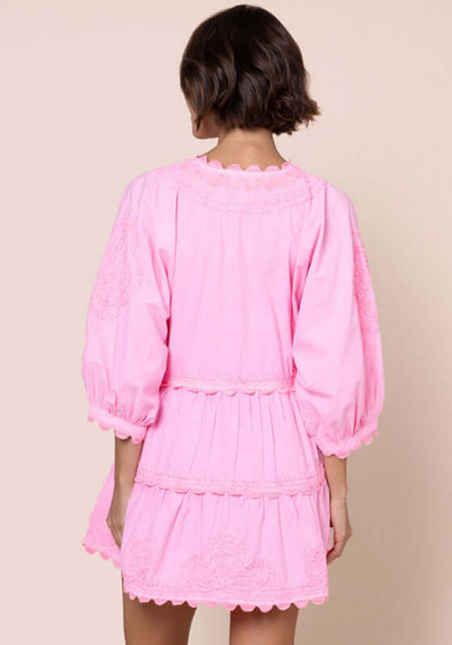 Poplin Tiered Mini Dress Flamingo by Juliet Dunn, showcasing the back view with puffy sleeves and scalloped details.