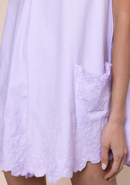 Poplin Floral Low Back Dress Lilac by Juliet Dunn featuring a close-up of the embroidered hem and playful pocket detail.