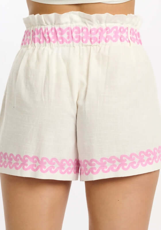 Mady Beach Shorts by Miss June featuring a crisp white fabric with vibrant pink paisley print and an elasticated waist.