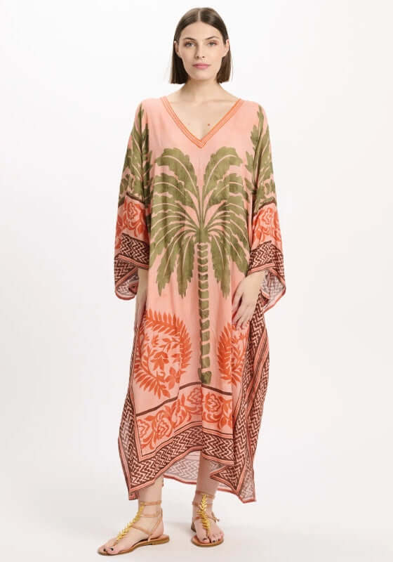 Rhoda Long Kaftan Peach by Miss June featuring a tropical palm print in olive green and orange on a peach background.