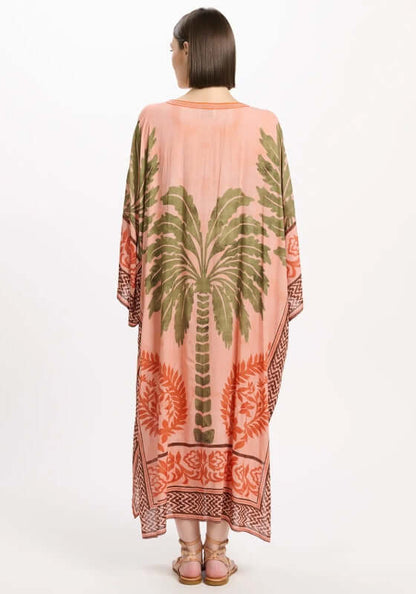 Rhoda Long Kaftan Peach by Miss June featuring a tropical palm print and flowing sleeves, showcased from the back.