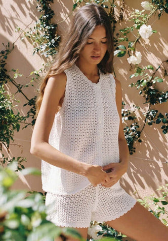 Pointelle Shorts Seashell by Peony, model wearing elegant perforated summer outfit in soft seashell hue against floral backdrop.