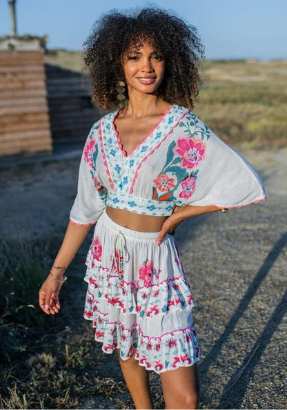 Bonaire Top White Pink by Piti Cuiti, featuring floral print and open sleeves, perfect for warm-weather beach days.