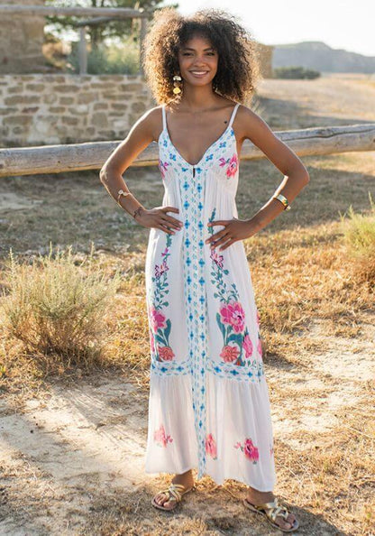 Bonaire Dress White Pink by Piti Cuiti on a model in a floral maxi dress in a sunlit outdoor setting.