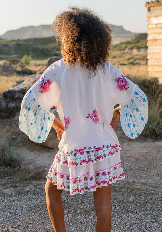Bonaire Skirt White Pink by Piti Cuiti, showcasing a vibrant tiered mini skirt with shired drawstring waist and floral print.