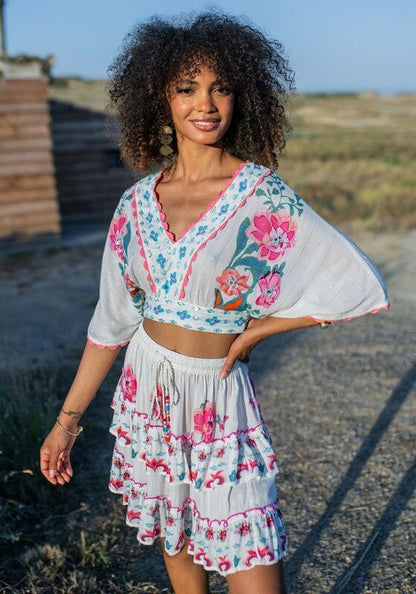 Bonaire Skirt White Pink by Piti Cuiti, featuring a tiered design with vibrant hand-painted pink details.