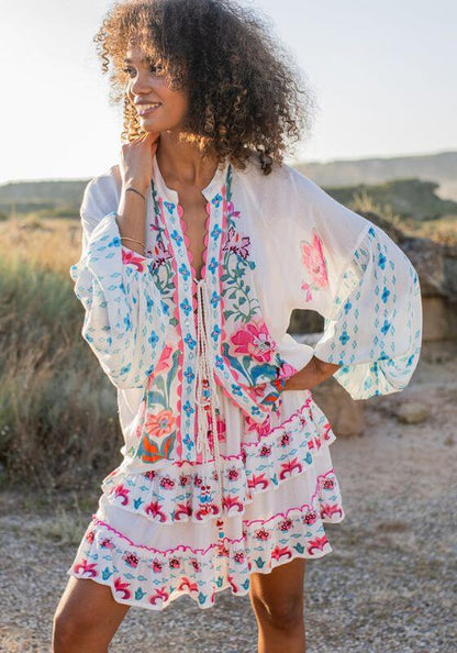 Bonaire Skirt White Pink by Piti Cuiti, showcasing a model wearing a vibrant mini skirt with floral details.