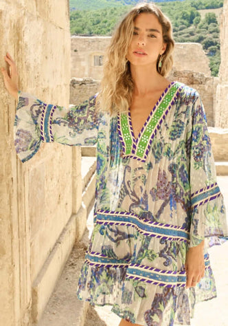 Ocean Pearl Short Dress by Piti Cuiti worn by a model, featuring a V neckline and flared sleeves in blue and green patterns.