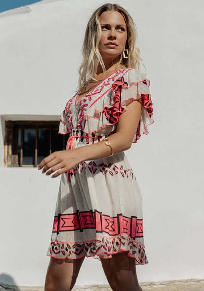 Sidi Kaouki Short Dress by Piti Cuiti, model wearing dress with vibrant embroidery and tassel waist in a sunny setting.