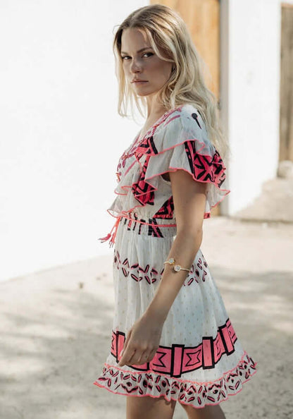 Sidi Kaouki Short Dress by Piti Cuiti, featuring vibrant neon pink embroidery and a flattering V-neckline.
