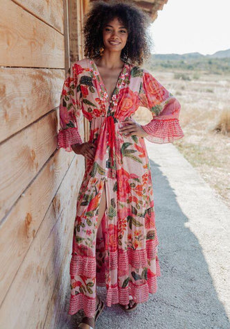 St Barths Beach Dress Orange by Piti Cuiti, vibrant floral dress with peplum sleeves in tropical setting.