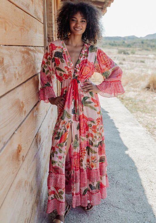 St Barths Beach Dress Orange by Piti Cuiti, vibrant floral dress with peplum sleeves in tropical setting.