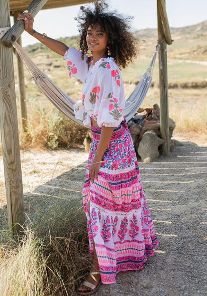 Zanzibar Long Skirt Pink Indigo by Piti Cuiti, showcasing a woman in a colorful, flowing beach skirt with floral patterns.