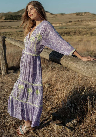 Sahara Purple Long Dress by Piti Cuiti, a beautiful model wearing a flowy purple maxi dress in a natural setting.